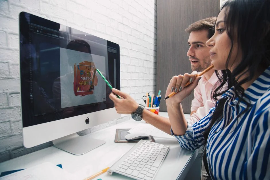 Two people working on a laptop to shop online, illustrating today’s e-commerce trends.